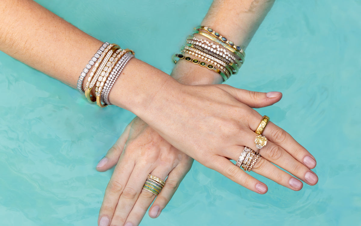 Closeup of yellow gold diamond wrist and hand candy from Shop the Look Topanga Canyon in swimming pool; 323-404-2959 for shop help